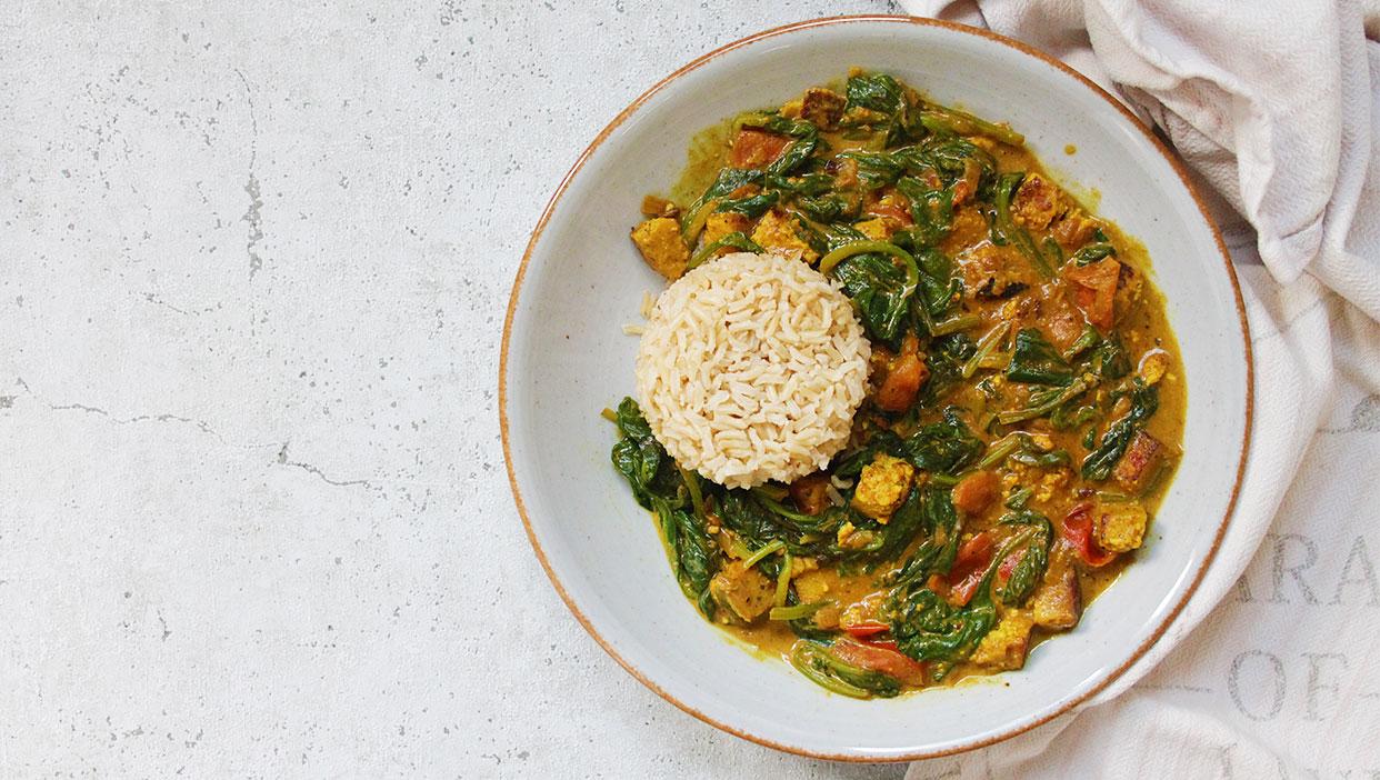 Indischer Teller mit Vollkornreis und Mango-Tofu in cremiger Kokoscurry-Soße