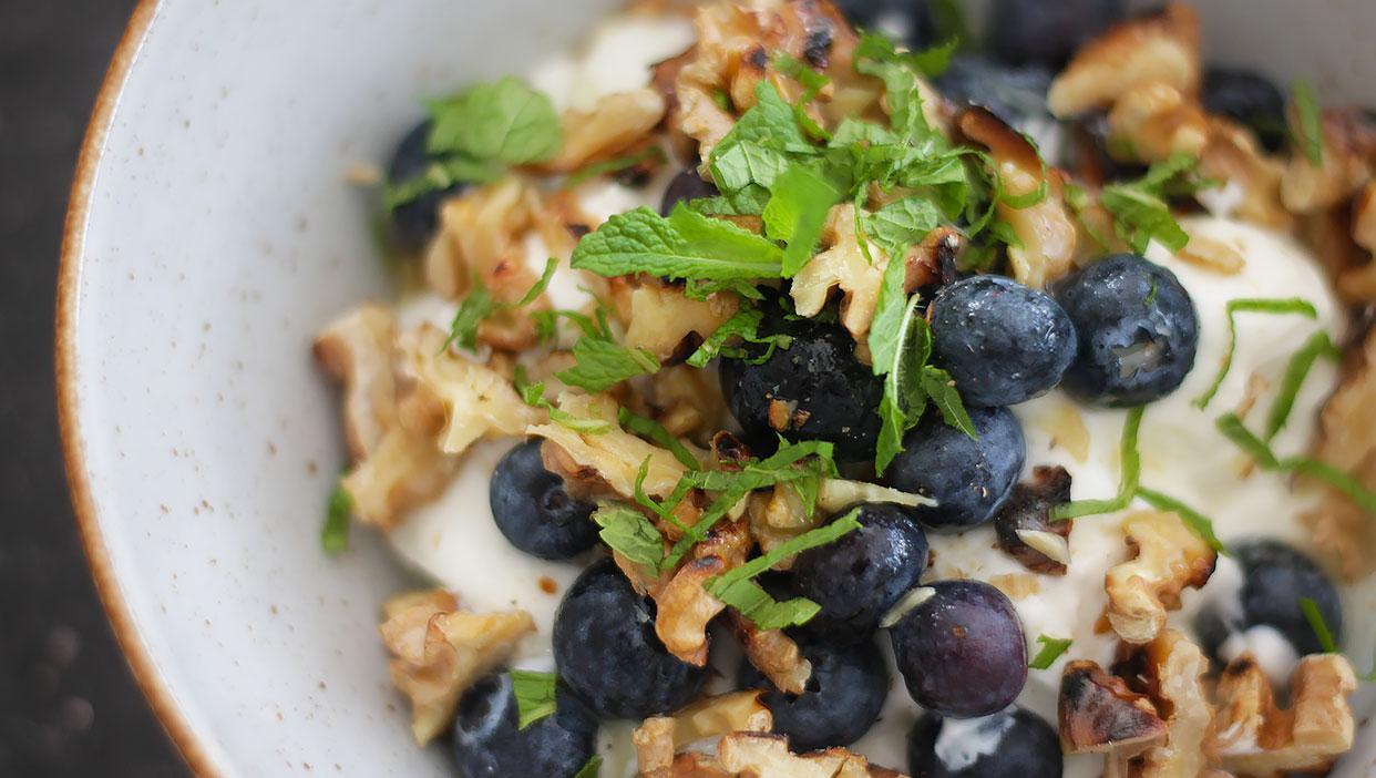 Griechischer Joghurt mit gerösteten Walnüssen, Minze und Blaubeeren